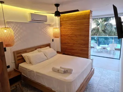 a bedroom with a bed and a large window at Camino Palmero Coveñas in Coveñas
