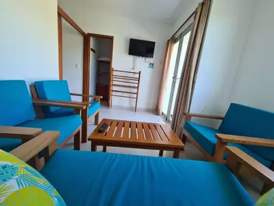 a living room with blue chairs and a table at Camino Palmero Coveñas in Coveñas