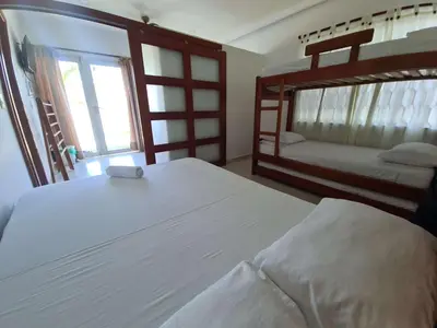 a bedroom with two bunk beds and a window at Camino Palmero Coveñas in Coveñas