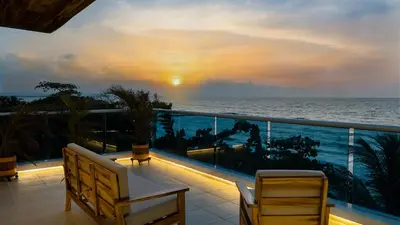 a balcony with a view of the ocean at sunset at Camino Palmero Coveñas in Coveñas