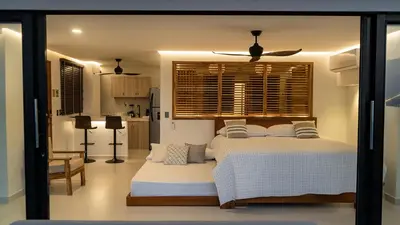 a bedroom with a large bed and a kitchen at Camino Palmero Coveñas in Coveñas
