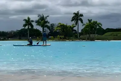 two people on a paddle board in the water at 1ra Cristal Lagoons de Colombia in Cartagena de Indias