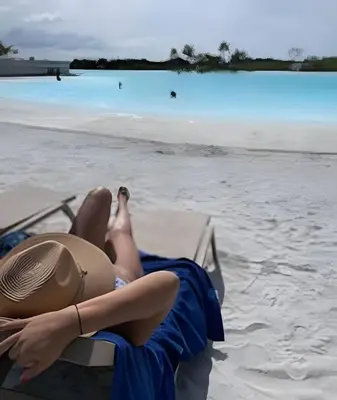 a woman in a hat laying on a beach at 1ra Cristal Lagoons de Colombia in Cartagena de Indias