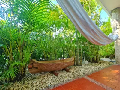 a wooden boat sitting in a room with plants at Lujosa cabana con piscina playa y servicio in San Silvestre