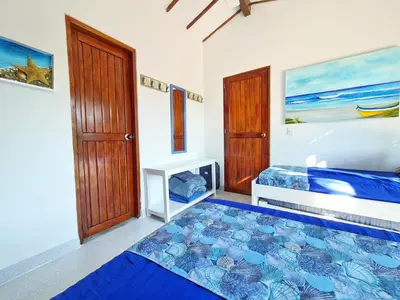 a bedroom with two beds and a door at Lujosa cabana con piscina playa y servicio in San Silvestre