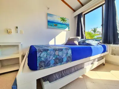 a bedroom with a bed with a view of the ocean at Lujosa cabana con piscina playa y servicio in San Silvestre