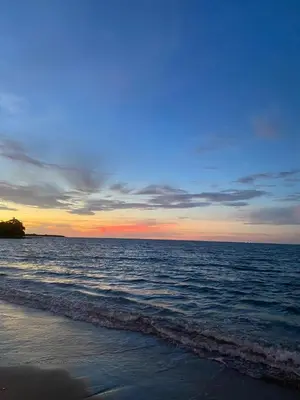 a sunset over the ocean with the shoreline at Las Margaritas Frente al Mar 2 in Coveñas