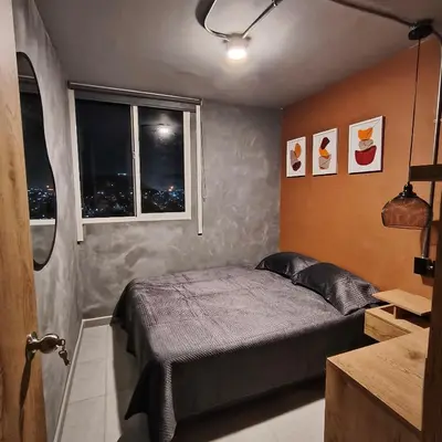 a small bedroom with a bed and two windows at Exclusive apartament near downtown and beach in Cartagena de Indias
