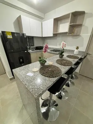 a kitchen with a counter with stools and a black refrigerator at Cartagena, Serena del Mar, Capriella in Manzanillo del Mar