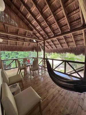 a room with a hammock and a table and chairs at City Escape Casa Mariguana in Turbaco