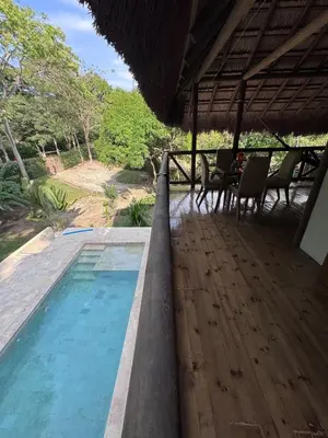 a swimming pool with chairs and a table on a deck at City Escape Casa Mariguana in Turbaco