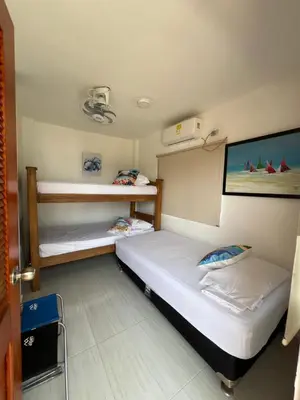 a bedroom with two beds and a tv on the wall at Asís apartamentos in Tolú