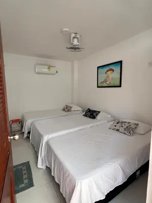 two beds in a room with white walls at Asís apartamentos in Tolú