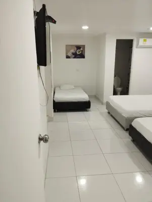 a room with two beds and a flat screen tv at HOTEL Shiloh in Cartagena de Indias