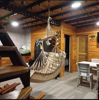 a hammock hanging in a room with a piano at Alta vista Turbaco in Cartagena de Indias