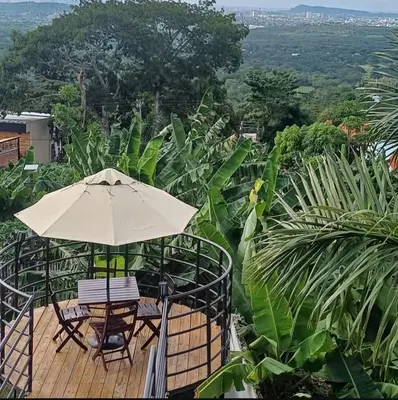 an umbrella and two chairs on a wooden deck at Alta vista Turbaco in Cartagena de Indias