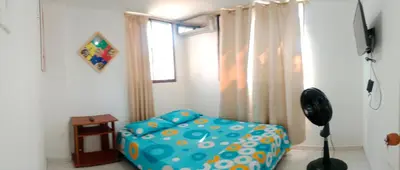 a living room with a couch and a window at Habitación con aire y piscina in Santa Veronica
