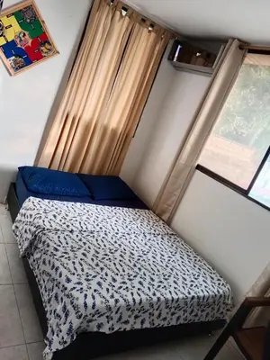 a small bed in a room with a window at Habitación con aire y piscina in Santa Veronica