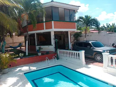 a house with a swimming pool in front of a house at Habitación con aire y piscina in Santa Veronica