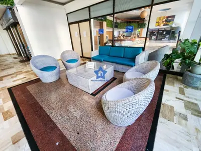 a lobby with wicker chairs and a blue couch at Apartamento Confort 13 Vista Caribe in Cartagena de Indias