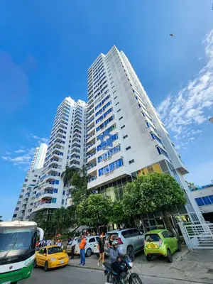 a tall building with cars parked in a parking lot at Apartamento Confort 13 Vista Caribe in Cartagena de Indias