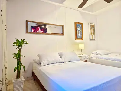 a bedroom with two beds and a mirror on the wall at Apartamento Caribe Hilton View - Piso 7 in Cartagena de Indias
