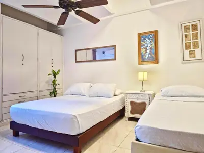 two beds in a bedroom with a ceiling fan at Apartamento Caribe Hilton View - Piso 7 in Cartagena de Indias