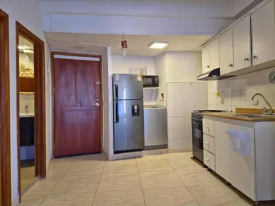a kitchen with a refrigerator and a red door at Apartamento Caribe Hilton View - Piso 7 in Cartagena de Indias