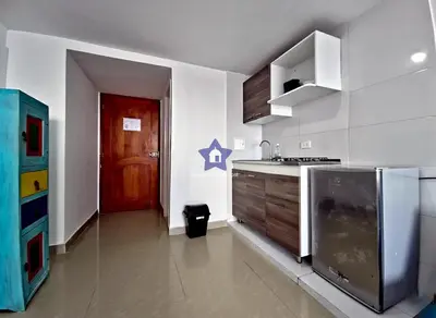 a kitchen with a refrigerator and a red door at Estudio Sky View - Piso 20 in Cartagena de Indias