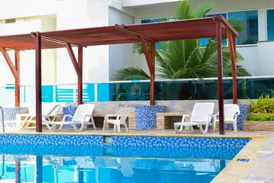 a pool with chairs and a gazebo next to a swimming pool at Estudio Vista Mágica - Piso 17 in Cartagena de Indias