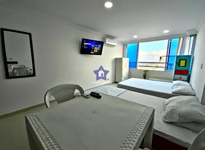 a room with two beds and a table and a mirror at Estudio Vista Mágica - Piso 17 in Cartagena de Indias