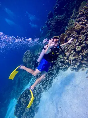 a man is playing with a frisbee in the ocean at Aquarius Diving Club y Cabañas in Rincón