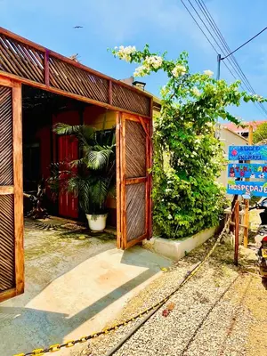 a building with a wooden door and a fence at Aquarius Diving Club y Cabañas in Rincón
