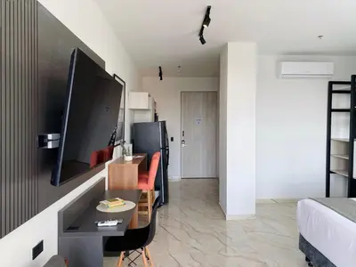 a room with a bed and a desk and a television at Muralla by Wynwood House in Cartagena de Indias