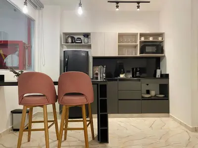 a kitchen with two chairs and a counter with a refrigerator at Muralla by Wynwood House in Cartagena de Indias