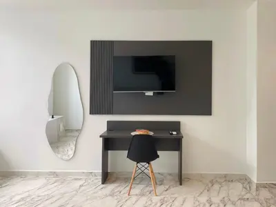 a room with a desk and a tv on a wall at Muralla by Wynwood House in Cartagena de Indias