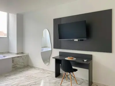 a room with a desk and a tv on a wall at Muralla by Wynwood House in Cartagena de Indias