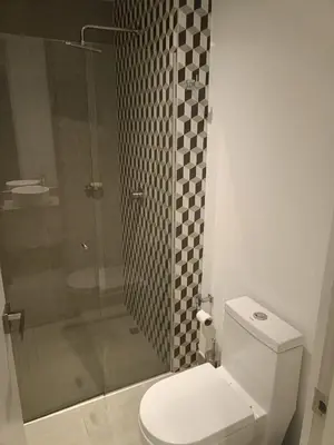 a bathroom with a toilet and a glass shower at Suite 803 Edif Distrito 90 in Barranquilla
