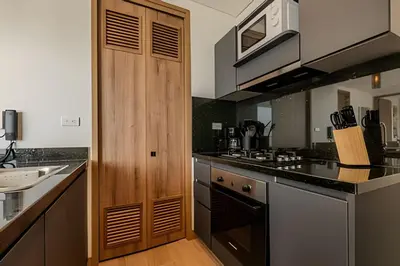 a kitchen with wooden cabinets and a stove top oven at Vista al Mar/ Centro Histórico/ Nuevo Piso 26 1BR in Cartagena de Indias