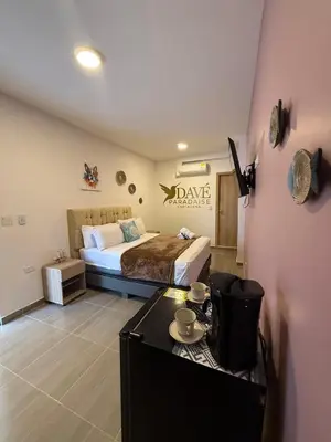 a bedroom with a bed and a table in it at Davé Paradise in Cartagena de Indias