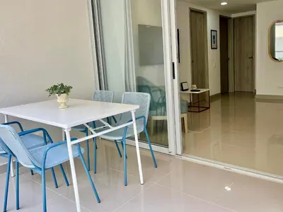 a white table and blue chairs in a room at Escapada 2BR en Ocean Drive in Cartagena de Indias