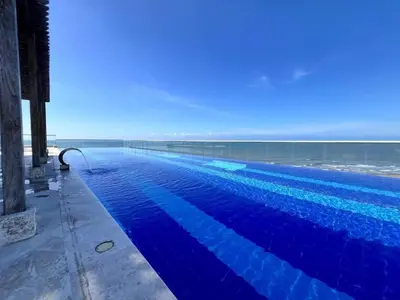 a large blue swimming pool next to the ocean at Escapada 2BR en Ocean Drive in Cartagena de Indias