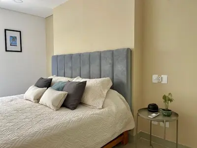 a bed with a gray headboard in a room at Escapada 2BR en Ocean Drive in Cartagena de Indias