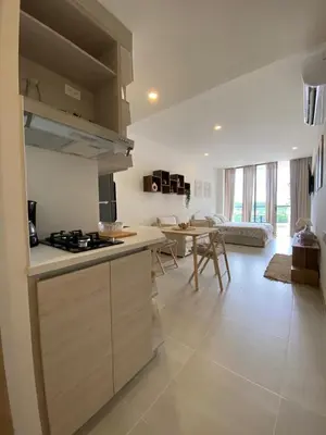 a kitchen and living room with a stove and a table at Hermoso y acogedor Monoambiente in Cartagena de Indias