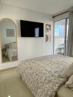 a bedroom with a large bed and a large mirror at Gran y cómodo Loft en Cartagena in Cartagena de Indias