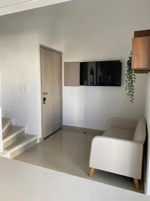 a white living room with a couch and a tv at Gran y cómodo Loft en Cartagena in Cartagena de Indias