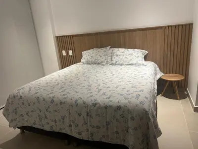 a bedroom with a bed with a blanket and a table at baia kristal paraiso aguas cristalinas in Cartagena de Indias
