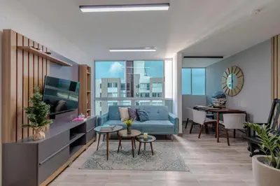 a living room with a blue couch and a table at Lux University Apt in Barranquilla