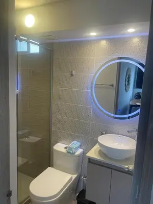 a bathroom with a toilet and a sink and a mirror at Lux University Apt in Barranquilla