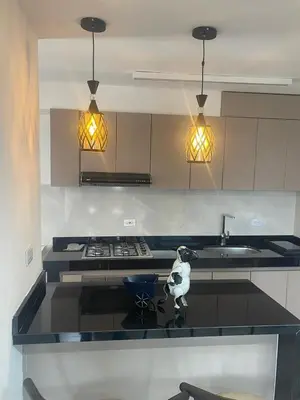 a kitchen with a counter with a sink and a stove at Lux University Apt in Barranquilla